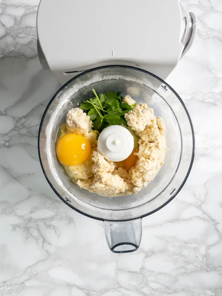 Eggs and parsley added to the dumpling mixture in the food processor