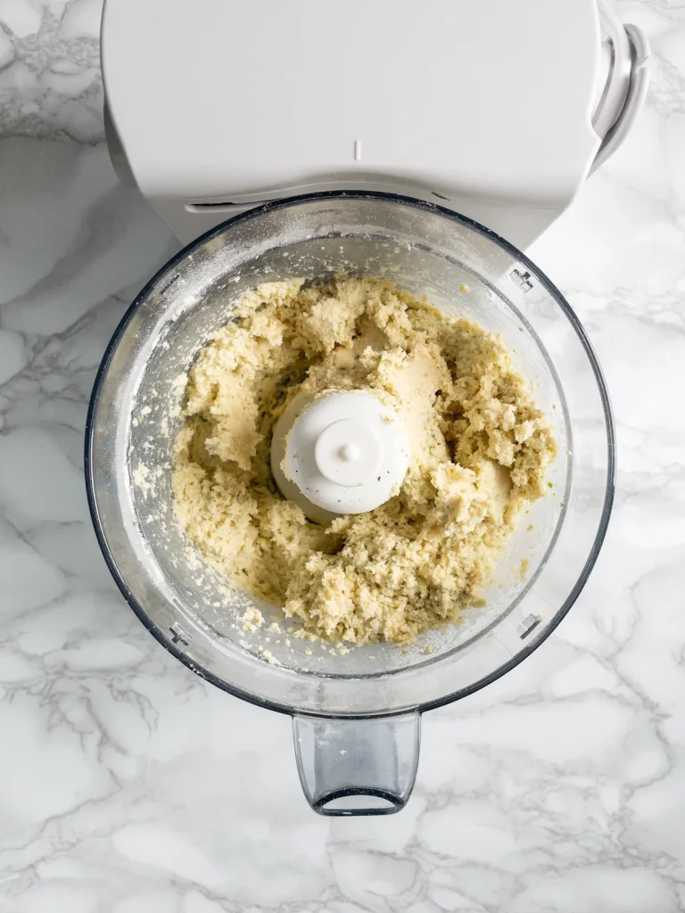 Finished dumpling mixture in the food processor looking like wet, sticky dough