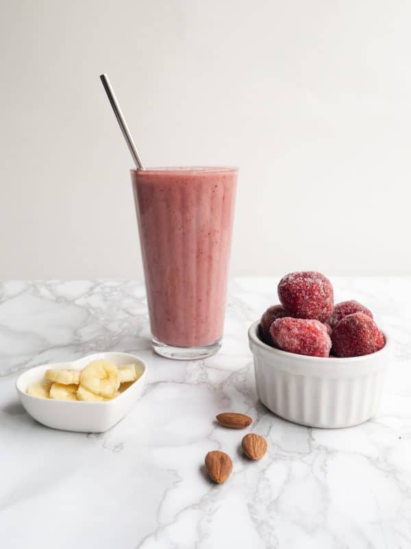 Strawberry Banana Smoothie along with ingredients of frozen strawberries and banana