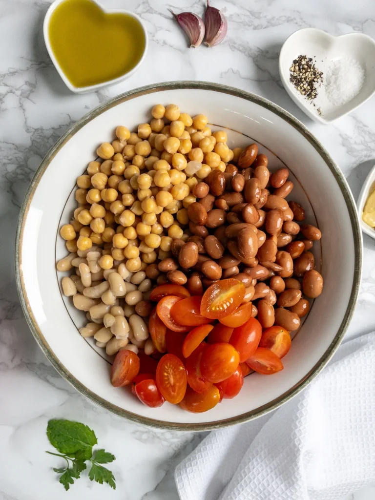 Chickpeas, borlotti beans and cannellini beans for vegan bean salad. Next add the tomaotes.