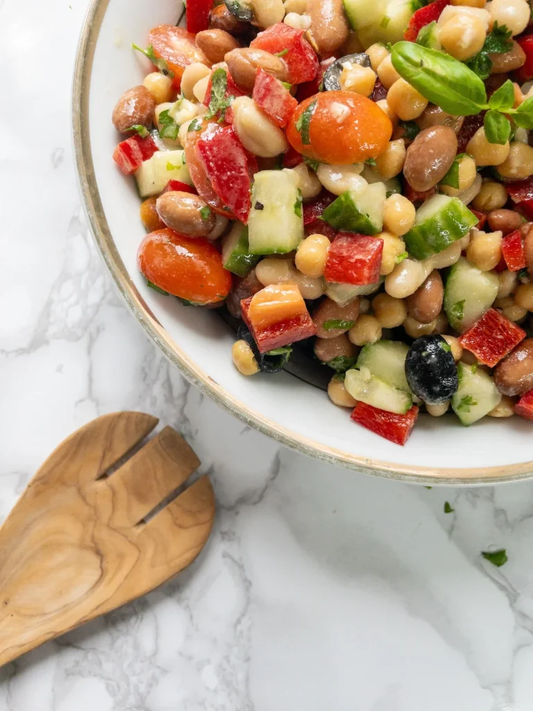 Toss the Mediterranean bean salad until everything is evenly coated in the dressing.