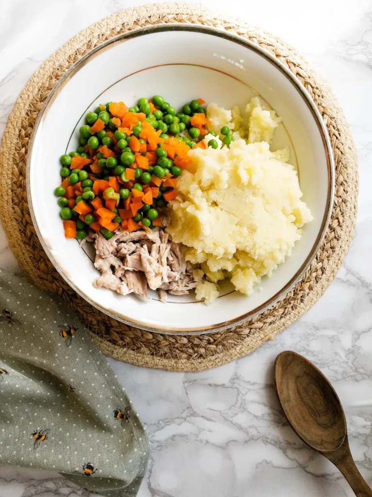 Finely diced carrots and peas are added to the Olivieh Salad.