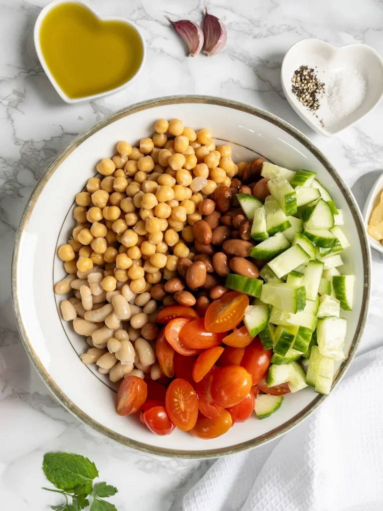 Chickpeas, borlotti beans, cannellini beans and tomatoes for vegan bean salad. Next, add the cucumber.