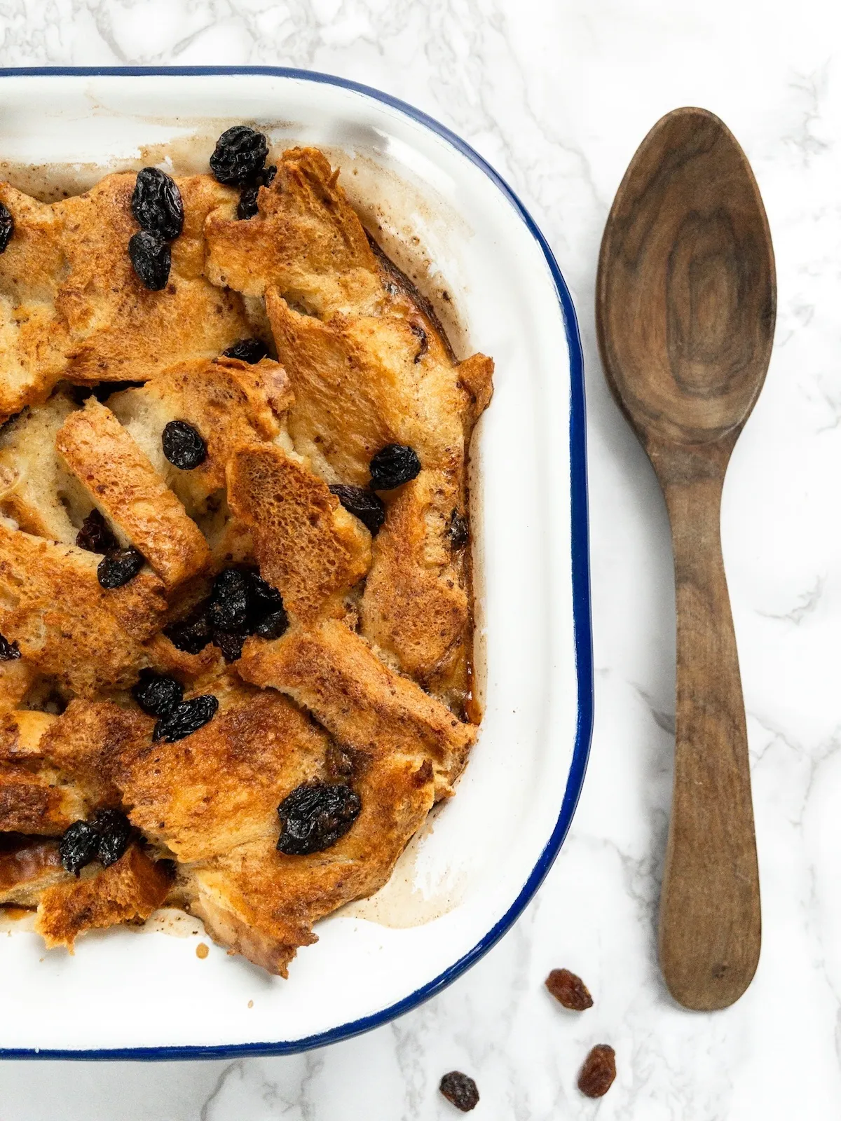 Rich dairy-free bread pudding served as a dessert, topped with raisins.