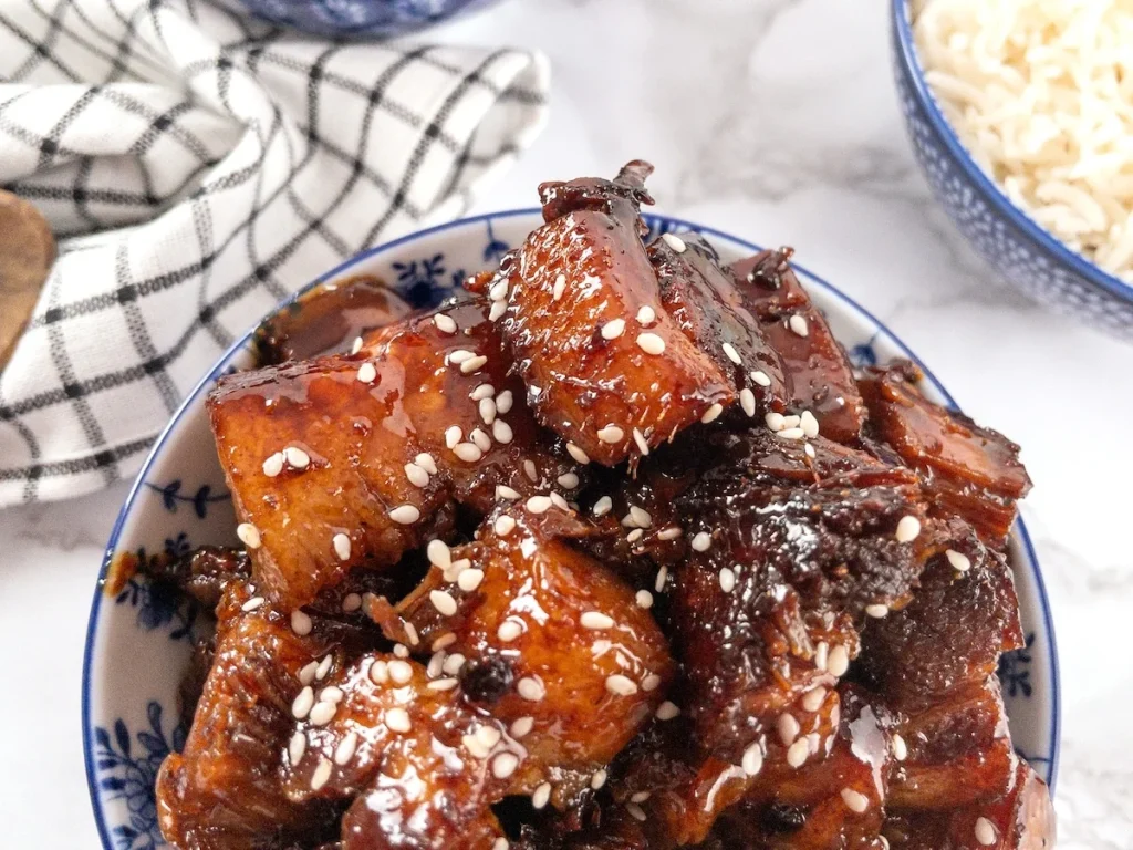 Plated Slow Cooker Sticky Pork Belly with sesame seed garnish