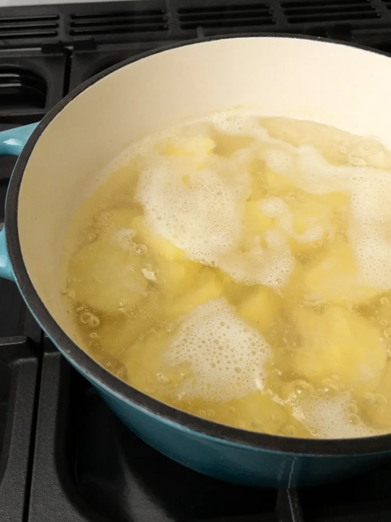 Potatoes boiling in a pot of water.