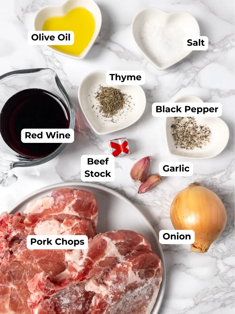 The ingredients for Instant Pot frozen Pork Chops with gravy, including onion, red win, garlic, stock and seasoning.