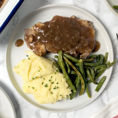 Plate with pork chops, mashed potatoes, and green beans.