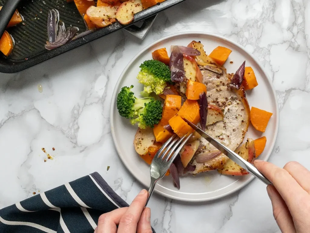 One-pan honey mustard pork chops dinner with sweet potatoes and apples.