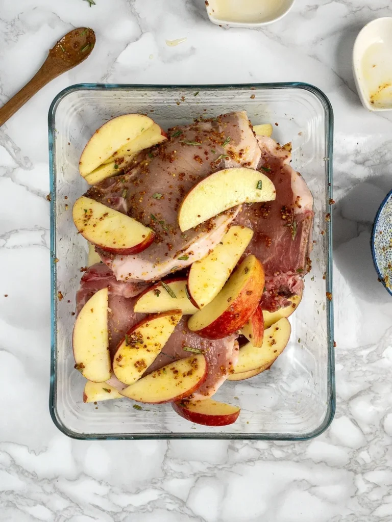 Pork and apples coated in honey mustard glaze, ready to bake