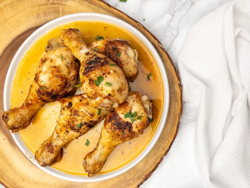 Finished pan-fried chicken drumsticks and gravy.