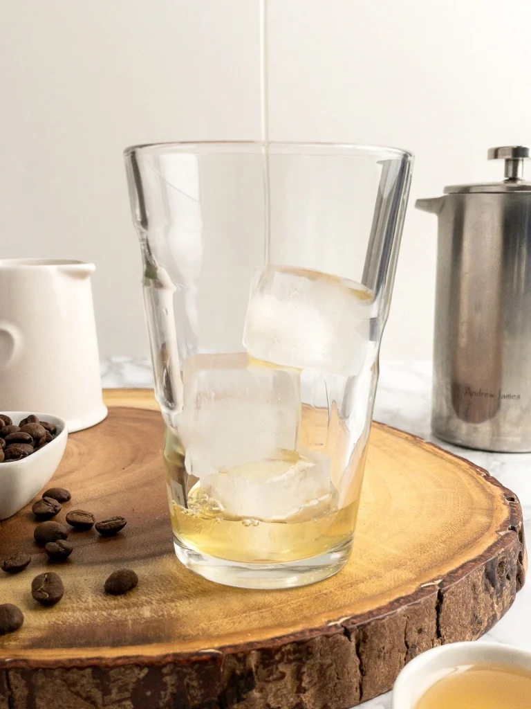 Ice cubes in a tall glass with honey simple syrup.