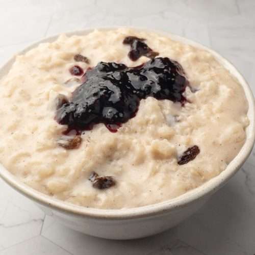 Close-up of dairy-free rice pudding with a dollop of jam on the top.